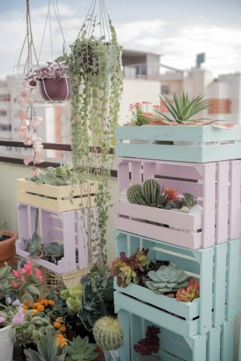 Upcycling-Ideen für einen Boho Balkon mit bemalten Holzkisten.